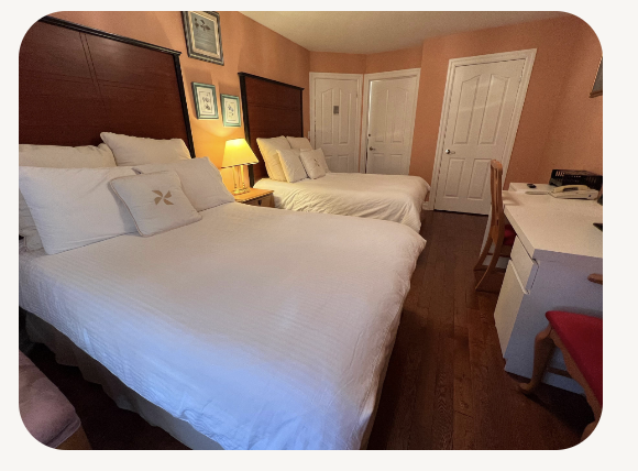 Room with two double beds and hardwood floors